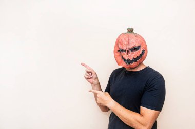 Balkabağı maskeli adam işaret ediyor.