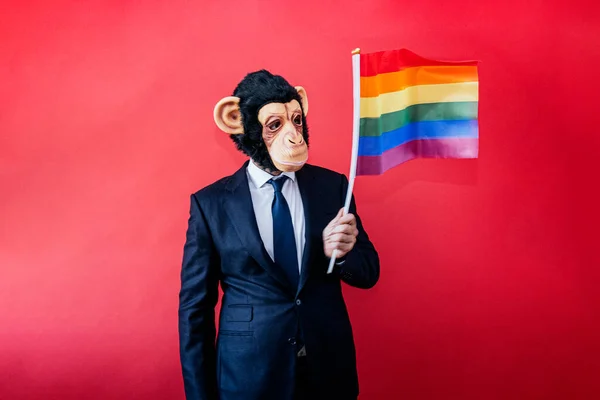 원숭이가면을쓰고 색깔의 깃발을 흔드는 사업가 — 스톡 사진