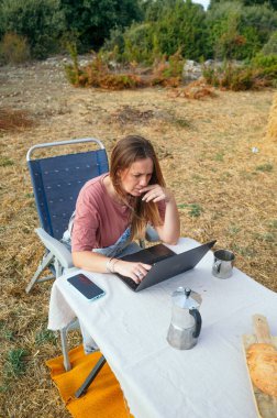 Kadın dışarıda dizüstü bilgisayar üzerinde çalışırken konsantre oluyor..