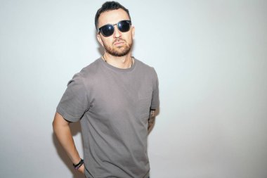 Güneş gözlüğü ve günlük kıyafet takan ciddi bir adam..