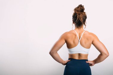 Kalçasında elleri olan, atletik fiziği ve kasları olan bir kadın.