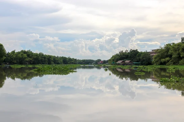 Bir ayna gibi nehre beyaz bulut yansıyan