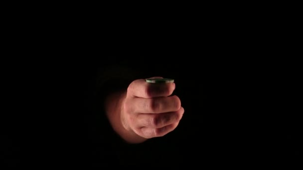 Mann im Dunkeln wirft hin und fängt Pokerchips ein — Stockvideo