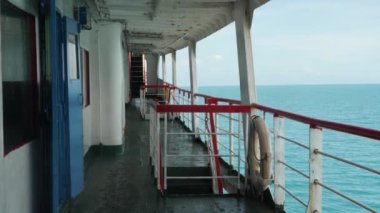 Güvertede, deniz dalgası arka planında yelkenli.