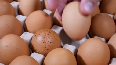 Tanınmayan adamın eli çiğ tavuk yumurtası alır.