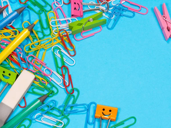 Paper clips on blue background with copyspace