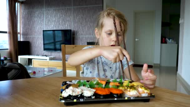 Kleines Mädchen probiert Variationsreihe von eingewickelten Rollen Sushi — Stockvideo