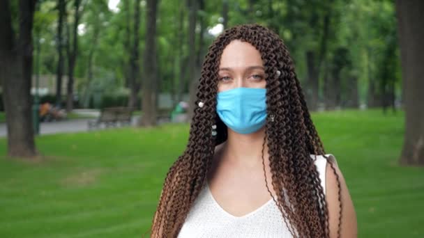 Довге кучеряве волосся самка знімає захисну маску для обличчя як захист від інфекційних захворювань — стокове відео