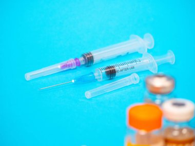 Mavi arka planda şırınga ve iğne