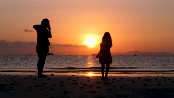Silhuetter av mor och dotter ser på solnedgången — Stockvideo