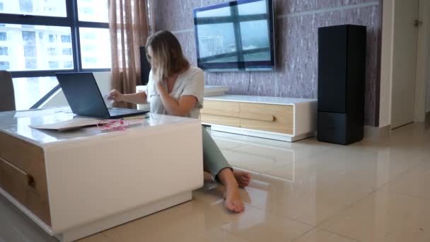 Feminino trabalhador tipo de texto no teclado do laptop e telefone celular falando — Vídeo de Stock