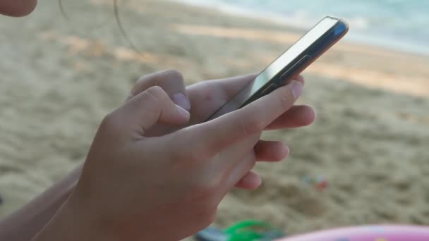 Las manos de las hembras usando Smartphone Negro en el fondo de agua de mar — Vídeo de stock