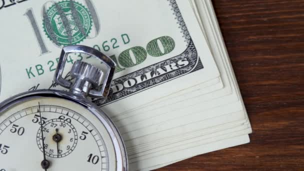 Honderd Amerikaanse dollars biljetten met analoge metalen stopwatch — Stockvideo