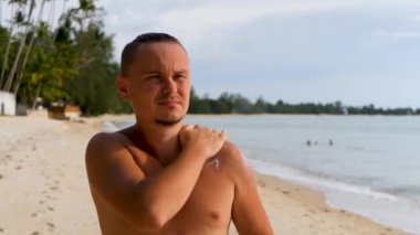 Deniz kıyısındaki arka plana güneş kremi sür.