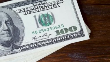 Kahverengi ahşap masa arkaplanındaki Dolar Faturaları