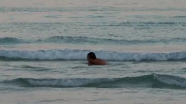 Sahildeki deniz suyuna atlayan komik adam.