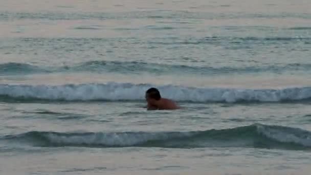 Забавный человек прыгает в морскую воду на пляже — стоковое видео