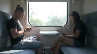 Yolcular yolcu vagonunda akıllı telefon kullanırlar.
