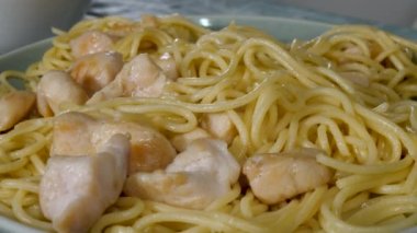 Tavuk eti ve yeşil tabakta pişmiş erişte.