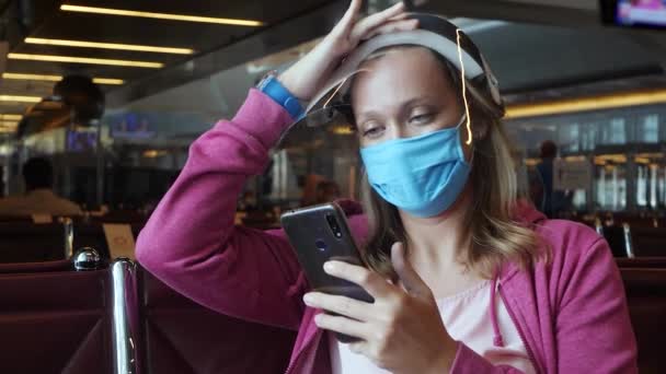 Kvinna i medicinsk mask och ansiktsskydd på flygplatsen — Stockvideo