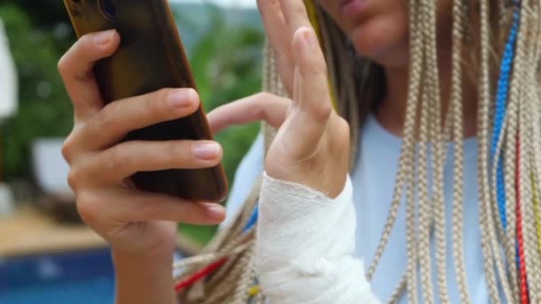 Frauenhandgelenk mit kleinem Mullverband oder medizinischem Verband nutzen Smartphone — Stockvideo