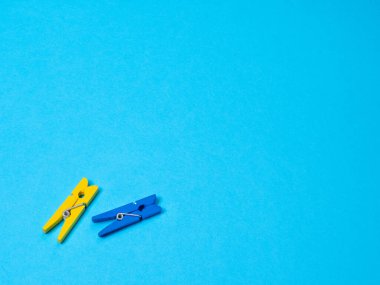 Mavi ve sarı ahşap mandallar mavi arkaplanda