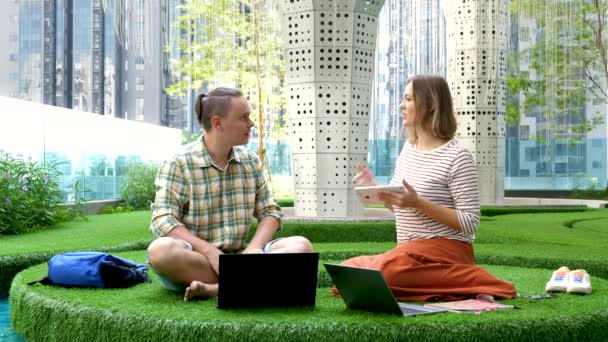 Mężczyzna i kobieta zespół dyskutować i rozmawiać projekt siedzi w coworking przestrzeń biuro — Wideo stockowe