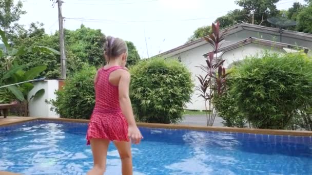 Маленький ребенок прыгать и плавать в бассейне после коронавируса ковид-19 эпидемии — стоковое видео