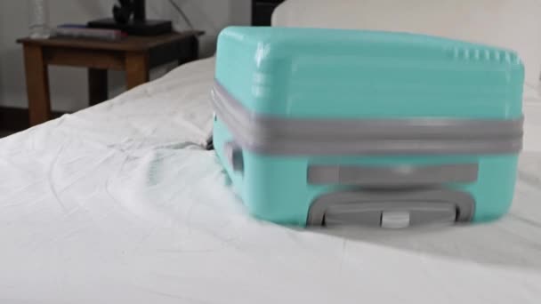 Zielona walizka podróżna bagażu na łóżku — Wideo stockowe
