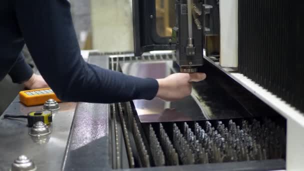 A mão dos engenheiros ajusta a máquina a laser CNC para cortar a placa de metal — Vídeo de Stock
