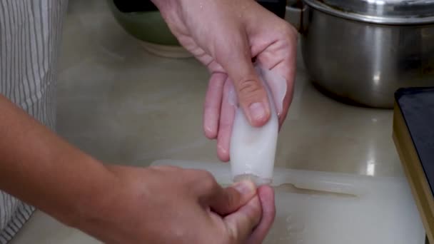 Weibliche Hand putzen und frischen Oktopus oder rohen Tintenfisch kochen — Stockvideo