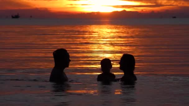 Щаслива сім'я плаває і грає у морській воді на пляжі — стокове відео