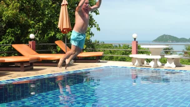 Молодий красивий чоловік стрибає в басейн — стокове відео