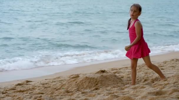 Niedliches kleines Mädchen spielt im Sand an der Küste — Stockvideo