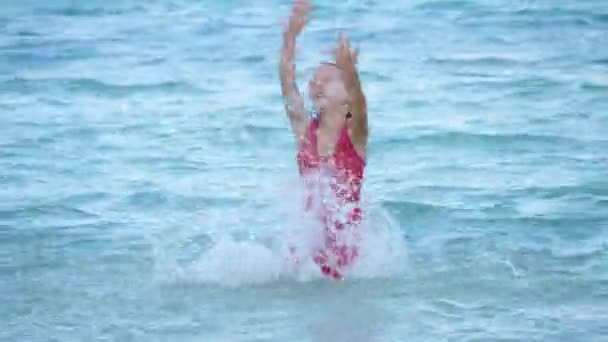 Cute child girl jump and swim in swimming pool in sea water — Stock Video