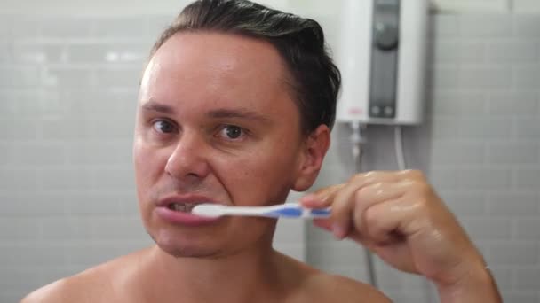 Muž čištění zubů doma v koupelně — Stock video