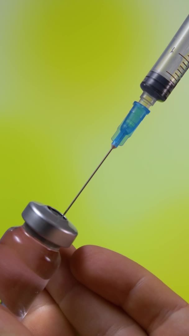 Spritze mit Coronavirus-Impfstoff zur Injektion auf gelbem Hintergrund — Stockvideo