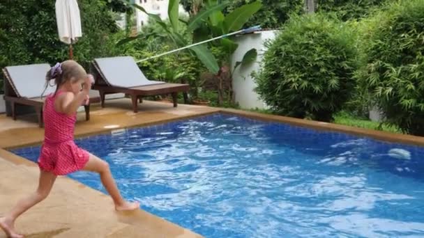 Criança de seis anos salta na piscina — Vídeo de Stock