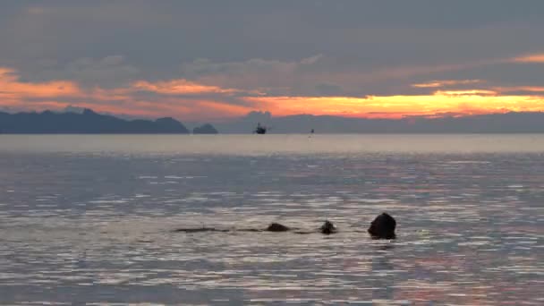 Kadın silueti dramatik günbatımında yüzer — Stok video
