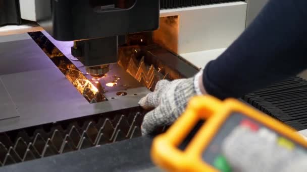 A mão dos engenheiros ajusta a máquina a laser CNC para cortar metal — Vídeo de Stock