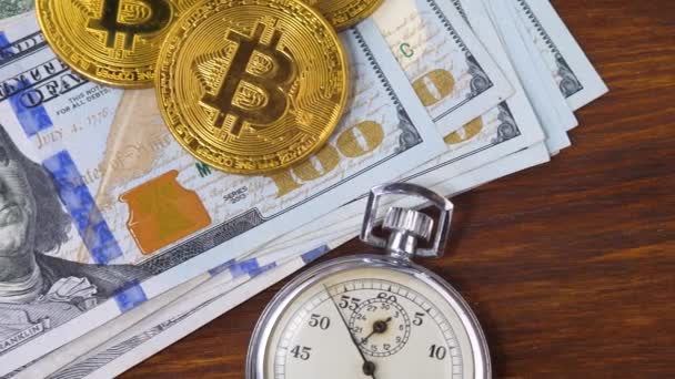 Tumpukan uang kertas dolar, Bitcoin BTC dan stopwatch logam perak — Stok Video