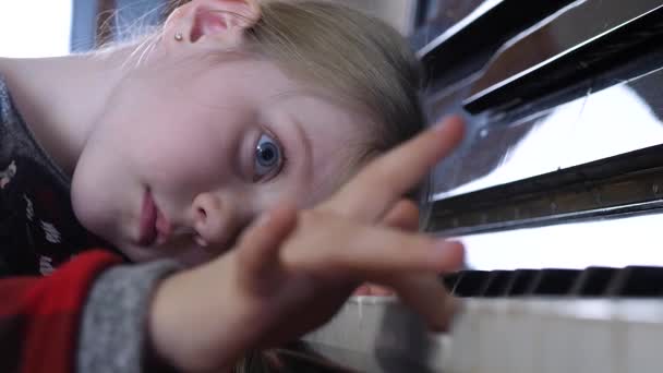Criança atraente estuda melodia musical na aula de piano — Vídeo de Stock