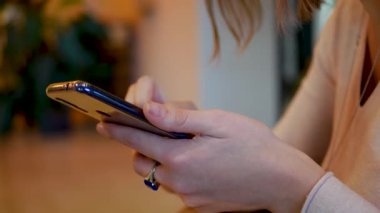Kadın elinde akıllı telefon kullanıyor.