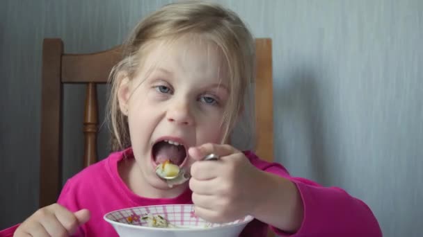 Fetița mănâncă supă acasă în bucătărie — Videoclip de stoc