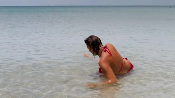 セクシーバックの美しいです女性の赤ビキニ上の海の背景 — ストック動画