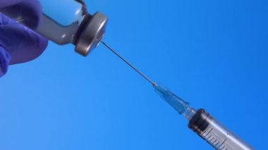 Doktorlar mavi steril lastik eldiven verdi. Şırıngadaki kuduz aşısını çevirdiler.