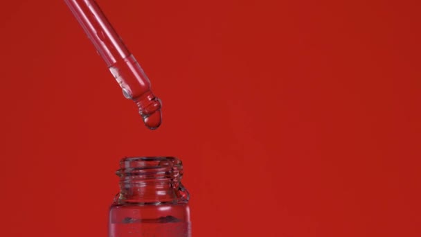 Druppel biologische etherische olie valt uit pipet in glazen fles — Stockvideo