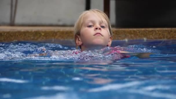 Маленька дитина плаває в басейні після епідемії коронавірусної хвороби — стокове відео
