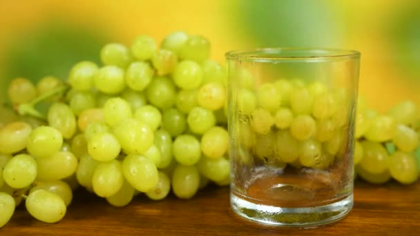 Vaso de jugo de uva y racimo de uvas blancas — Vídeo de stock