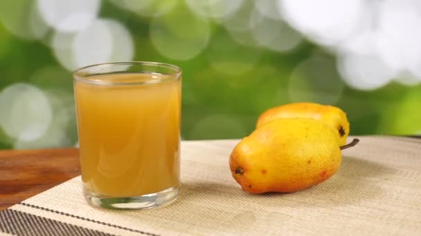 Reife Birne und Saft im Glas auf Holztisch — Stockvideo